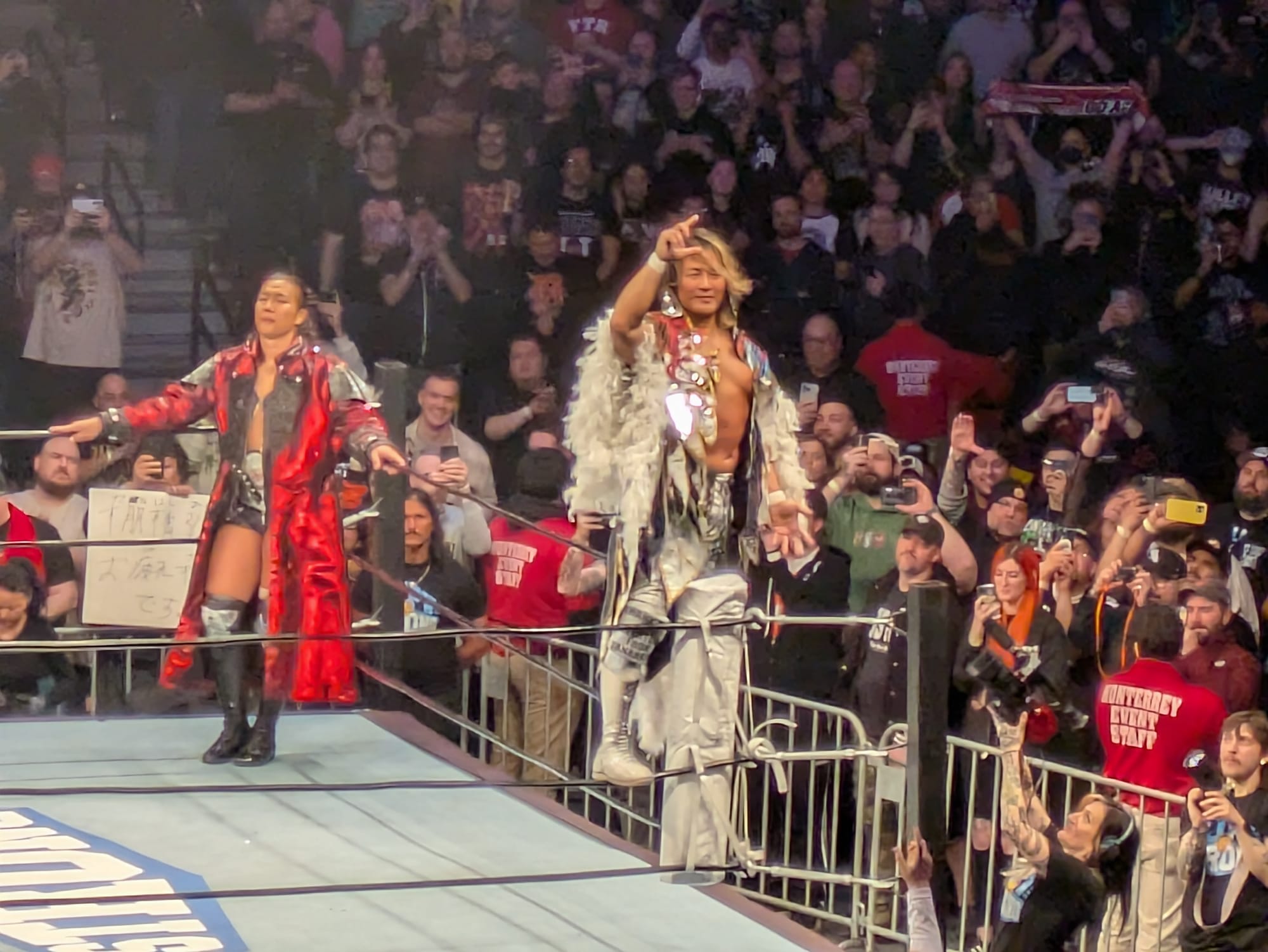 Tanahashi poses on the turnbuckle as Takeshita awaits.