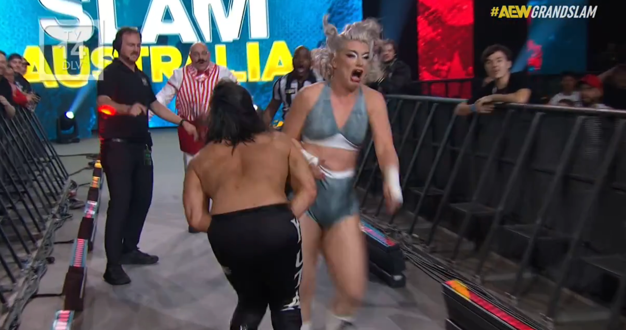 Toni Storm heading down the aisle while kicking Wheeler Yuta in the junk